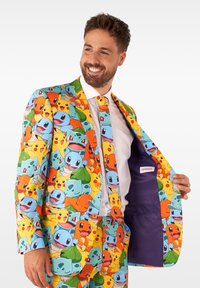 Kleurrijk pak met verschillende Pokémon-personages in blauw, oranje, groen en geel. Inclusief een bijpassende stropdas en paarse binnenvoering.