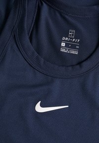 Maglietta sportiva Dri-FIT di colore blu navy con scollo rotondo, texture liscia e logo Nike bianco sul davanti. L'etichetta della taglia mostra la misura small.