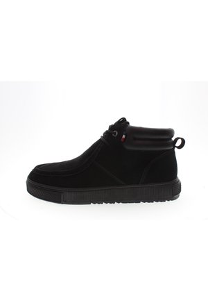 Botas de tobillo de ante negro con suelas de goma, punta redonda, cordones en la parte delantera y un cuello acolchado con un pequeño lazo en la parte trasera para facilitar su uso.