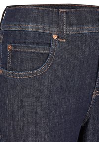 Jeans in denim blu scuro con una texture liscia, cuciture in rame e una tasca frontale visibile. Presentano un design classico per il giro vita.