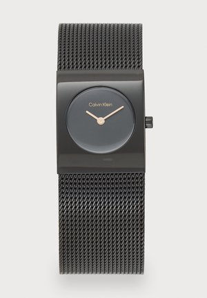 Montre rectangulaire noire avec finition mate, dotée d'un cadran gris foncé, d'accents en or rose sur les aiguilles et d'un bracelet en métal maillé.