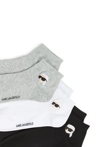 Three pairs of ankle socks in grey, white, and black cotton blend, featuring a logo and embroidered figure wearing sunglasses.