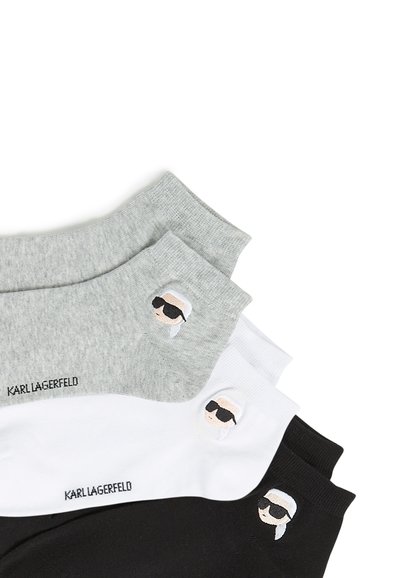 Trois paires de chaussettes de cheville en mélange de coton gris, blanc et noir, arborant un logo et une figure brodée portant des lunettes de soleil.