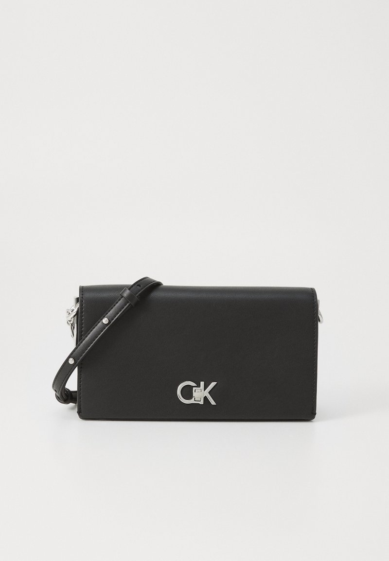 Black leather crossbody bag with silver hardware. Features a detachable strap and embossed logo on the front. Flat design, smooth texture.