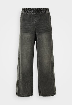 Pantalons en denim noir délavé avec taille élastique et jambes larges, présentant des détails de coutures verticales discrètes sur les côtés.