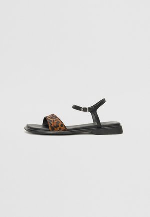 Sort sandal i læder med leopardprint, ankelrem, flad sål, åben tå og et minimalistisk design.