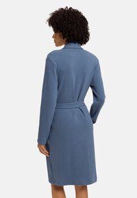 Robe blu a maniche lunghe con vita regolabile, caratterizzata da una consistenza morbida e un colletto, progettata per comfort e facilità d'uso.