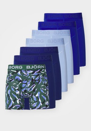 Ein Pack mit sieben Boxershorts in verschiedenen Blautönen und Grüntönen. Ein Paar hat ein Camouflage-Muster; alle haben markierte Taillenbänder.