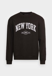 Sudadera negra con "NEW YORK" en letras blancas y en negrita, escote redondo, mangas largas y puños acanalados con un acabado texturizado.