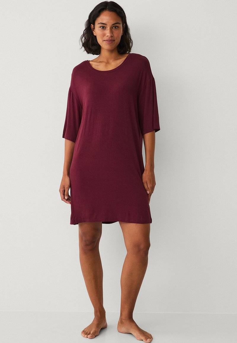 Bordeaux kortemouwen jurk van zacht materiaal, met een losse pasvorm en een brede halslijn, die boven de knie eindigt.