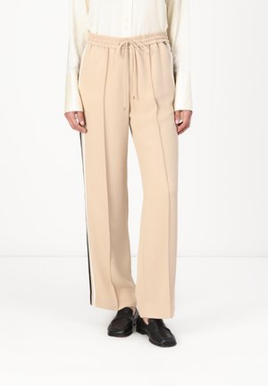 Beige wijde broek met een elastische tailleband, trekkoorddetail en zwarte zijstrepen. Glad, zacht materiaal met een comfortabele pasvorm.