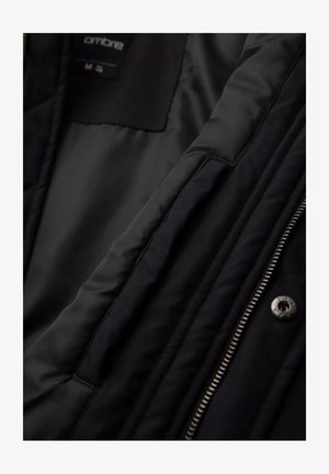 Wnętrze czarnej kurtki, gładki materiał o pikowanej strukturze, widoczne detale zamka błyskawicznego i zatrzasku, metka rozmiaru umieszczona w lewym górnym rogu.