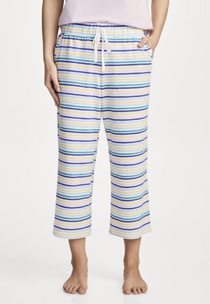 Person trägt kurz geschnittene, mehrfarbige, horizontal gestreifte Hose mit elastischem Bund und Kordelzug, steht barfuß.