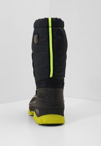 Bottes hautes noires et grises avec une tige texturée, une bande arrière vert néon et une semelle épaisse. Dotées de ferrures de marque et d'un talon renforcé.