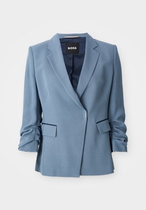 Blazer ajustado azul claro com lapela notched, dois bolsos frontais, mangas dobradas e fechamento frontal simples. Feito de um tecido suave.