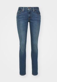 Blå denim slim-fit jeans med fem lommer, synlig søm og glidelås. Har en lett falmet tekstur for ekstra detaljer.