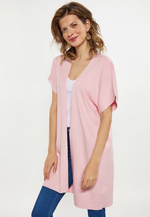 Hellrosa, offen getragenes Cardigan mit kurzen Ärmeln, V-Ausschnitt-Design, aus weichem Stoff, bis zur Mitte des Oberschenkels reichend. Tragen über einem weißen Oberteil.