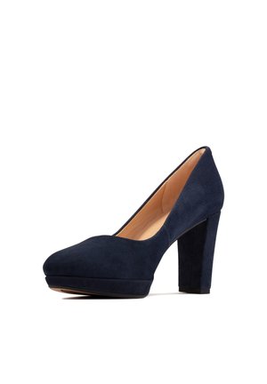 Tacones de plataforma de ante azul marino con punta redonda y un tacón grueso. Textura suave con una silueta elegante.