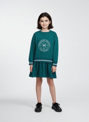 Teal sweatshirtkjole med lange ærmer, der har et cirkulært grafisk design på brystet og en samlet nederdel. Parret med sorte sko.