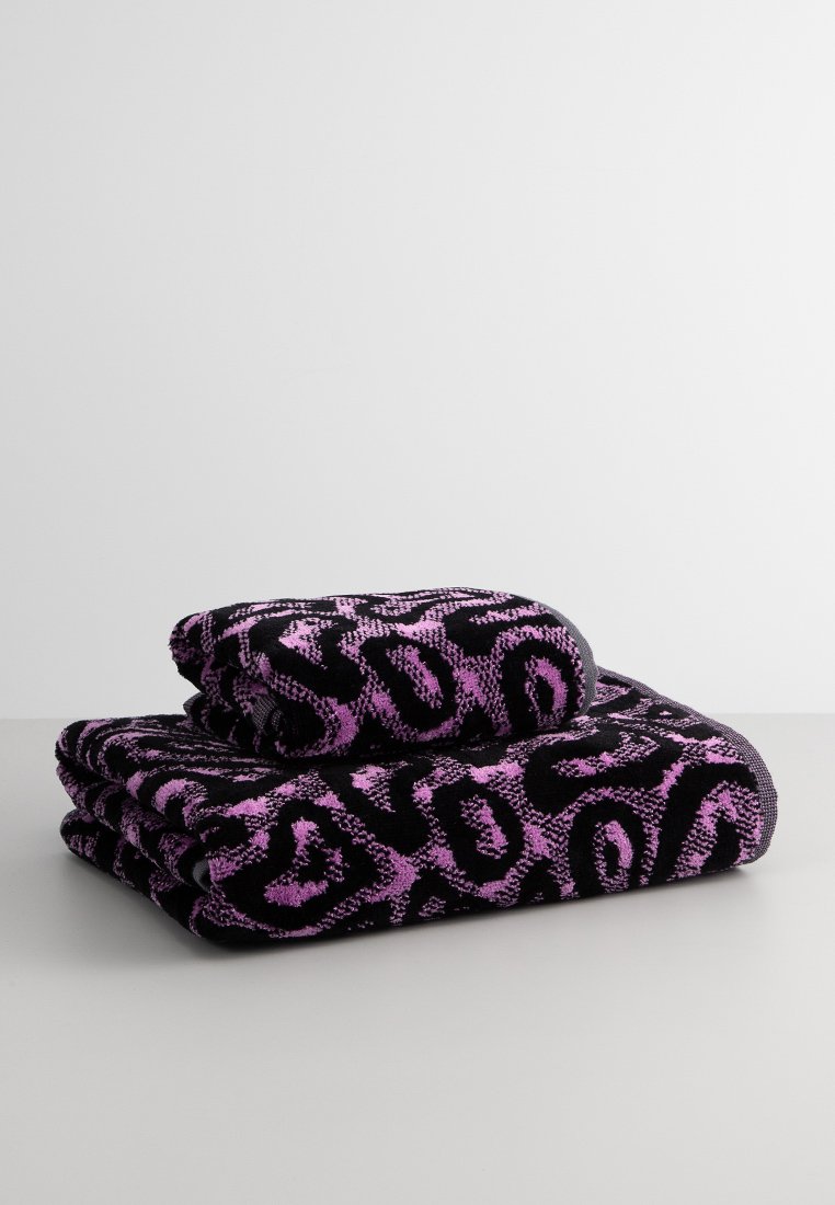 Serviettes noires avec un motif abstrait rose audacieux, empilées avec une texture pelucheuse et une bordure noire solide.