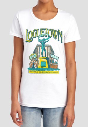 Woman wearing a white T-shirt with LoGuetown text and colorful graphic of statue, circus tent, building, and market stall.