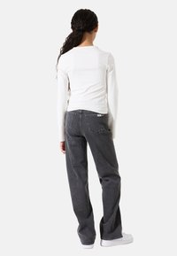 Zwarte jeans met een relaxte pasvorm, van katoen met een vijf-pocket ontwerp. Voorzien van een merkpatch op de achterkant en zichtbare stikdetails.