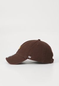 Brown cap with a curved brim, featuring a yellow logo on the front and a white '47' embroidery on the side, set against a plain background.