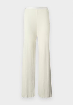 Labave hlače krem boje s žičanom teksturom, trapezastog oblika i rubom s neobrađenim završetkom, s elastičnim pojasom.