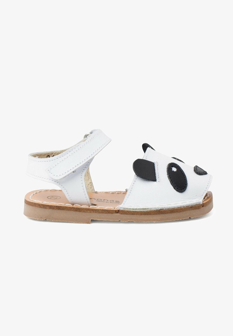 Sandales blanches pour enfants avec une sangle Velcro et des détails de visage de panda noir à l'avant, semelle plate marron et talon ouvert.