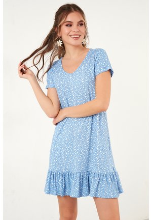 Blaues Blumendruckkleid mit kurzen Ärmeln, V-Ausschnitt und Rüschensaum. Leichter Stoff mit weicher Textur, der kleine weiße Akzente aufweist.