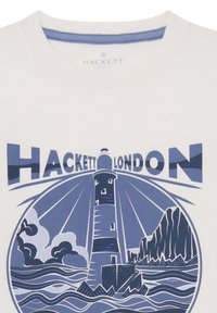 T-shirt en coton blanc avec un graphique de phare bleu, des vagues et des montagnes, accompagné du texte "HACKETT LONDON" en police grasse de couleur bleue contrastante.