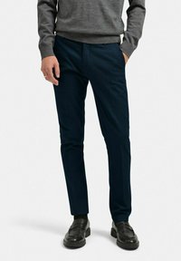 Navyblå skräddarsydda byxor i glattyg, med slim fit och rak bendesign, i kombination med svarta läderskor.