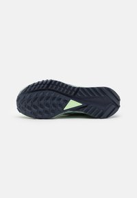 Semelle de chaussure de trail running en caoutchouc bleu marine foncé avec un motif texturé antidérapant. Présente un accent vert clair près de l'orteil avec un design triangulaire.