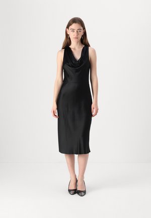 Zwarte satin mouwloze jurk met een gedrapeerde colsjaal halslijn, op kniehoogte, met een gladde textuur, gecombineerd met zwarte hoge hakken.