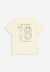 Cremfarbener Baumwoll-T-Shirt mit einem großen, bedruckten Grafik in grüner Schrift, die sagt "BUTCHER 18 OF BLUE" und einen used Look aufweist.