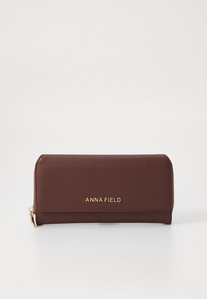 Brown synthetic leather wallet with gold brand logo, zipper closure, and a slim, rectangular design. Smooth texture with minimal accents.