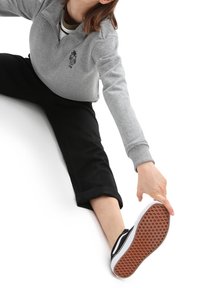 Grey zip-up sweatshirt with an embroidered design, black cropped pants, and black sneakers with a textured gum sole.