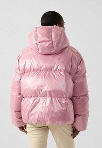 Dikke roze pufferjack met een glanzende afwerking, brede capuchon en elastische manchetten, met een gelaagd ontwerp en zichtbare stiksels.