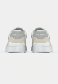 Μπεζ και γκρι δερμάτινα πάνινα παπούτσια με λευκή ελαστική σόλα, με ραμμένο λογότυπο στο πίσω μέρος και λεία υφή.