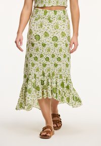 Groene rok met bloemenprint en een gerimpelde zoom, gemaakt van lichte stof. De rok heeft een gerimpelde tailleband en een vloeiende silhoeet.