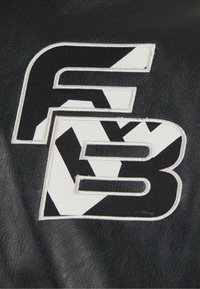 Cuir noir avec lettres brodées blanches et noires "F" et "B", présentant des formes angulaires et une texture lisse.