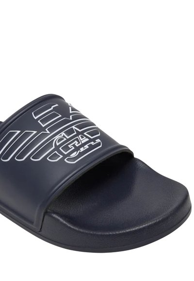 Σαγιονάρα σε ναυτικό μπλε με φαρδιά λωρίδα που φέρει ένα λευκό στυλιζαρισμένο λογότυπο και υφή στο πέλμα για καλύτερη πρόσφυση.