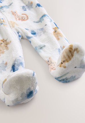 Bílý, nadýchaný pyžamový overal s barevnými zvířecími motivy; má měkký materiál, kulaté ponožkové zakončení a jemné modré akcenty.