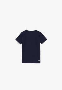 Navy blue cotton short-sleeve t-shirt with a round neckline. Features a small logo detail at the bottom left. Simple, solid color design.