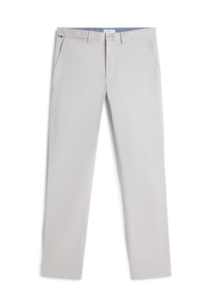 Pantalon homme gris clair slim fit avec poches latérales, fermeture à boutons, passants pour ceinture et petit détail de drapeau rouge, blanc et noir sur la ceinture.
