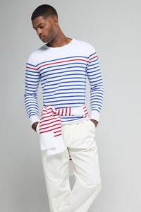 Langærmet stribet skjorte i hvid, blå og rød med en accentpanel. Kombineret med hvide bukser og et tørklæde bundet om taljen. Glat tekstur.