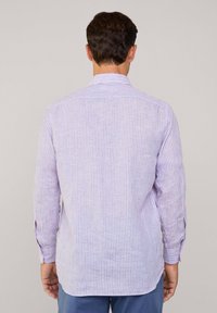 Camisa de manga larga en púrpura claro con finas rayas verticales. Presenta un cuello estándar, puños abotonados y un corte relajado.