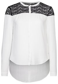 Blouse blanche à manches longues avec un yoke en dentelle noire, col rond, patte de boutonnage et un ourlet plissé plus long à l'arrière.