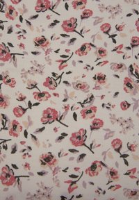 Weißer Stoff mit einem floralen Muster in verschiedenen Schattierungen von Rosa, Lavendel und Schwarz, mit verschiedenen Blumenformen und Blattanpassungen durchgehend.
