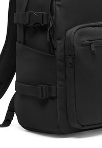 Fekete hátizsák tartós anyagból, több cipzáros zsebből, állítható pántokkal és egy oldalsó zsebbel, amely hálós panellel rendelkezik.